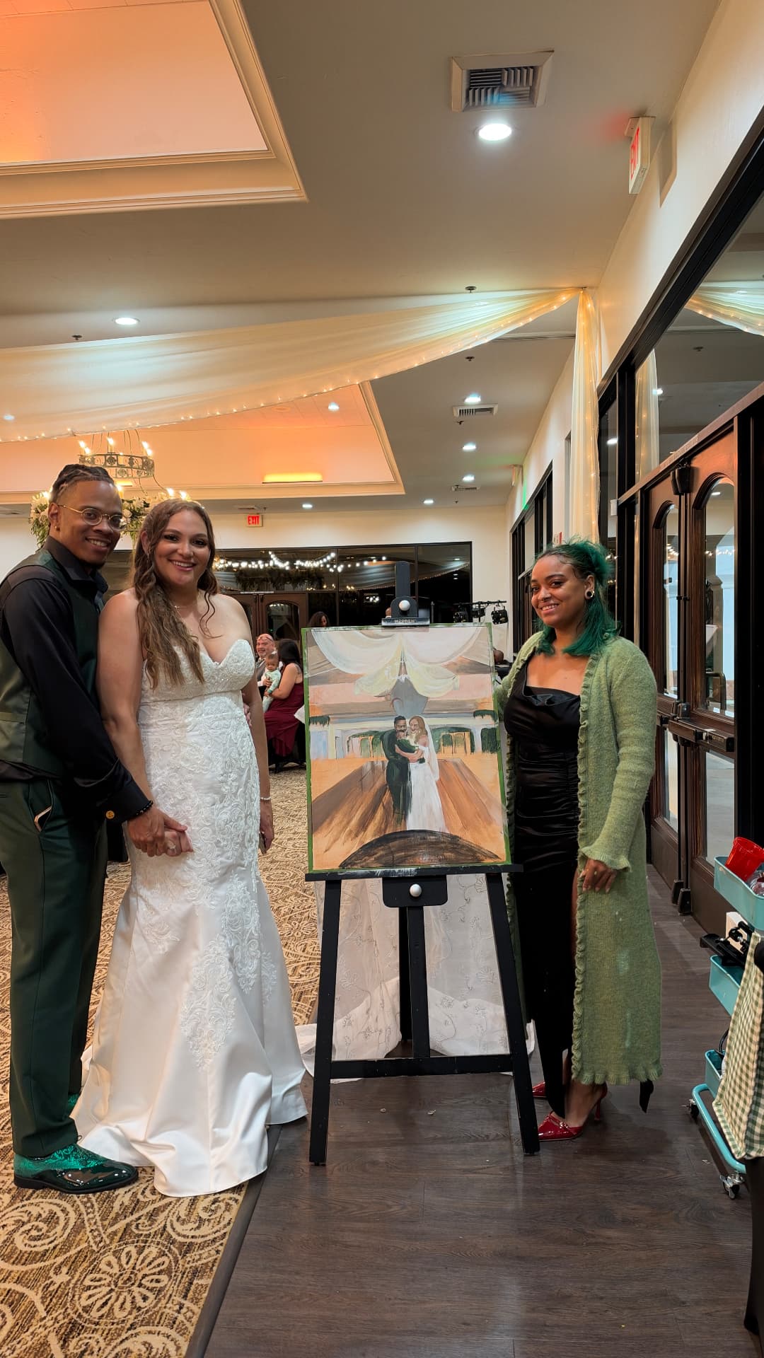 A bride and groom beside Chaleuh and the finished live painting of their first dance
