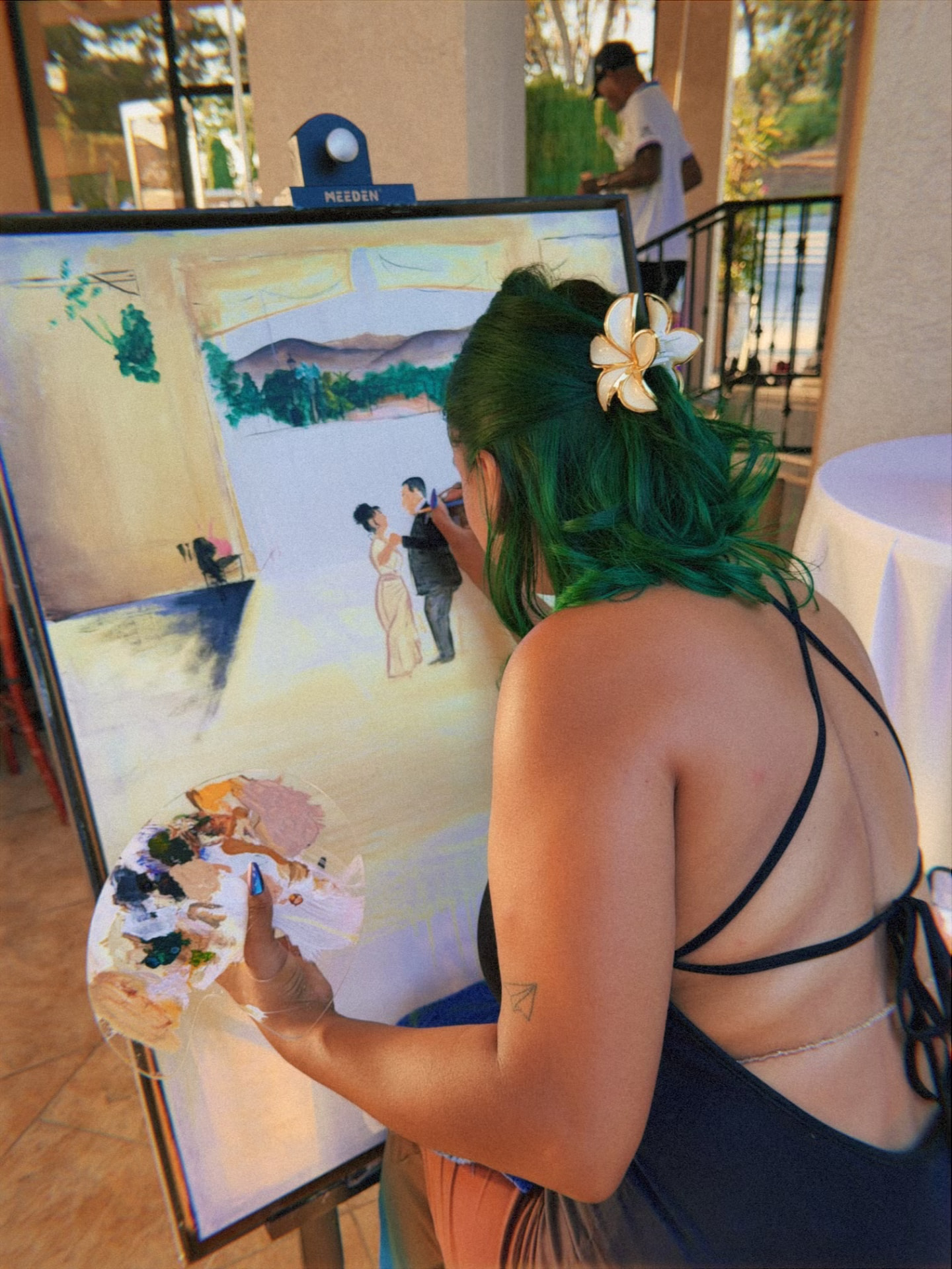 Live painter creating an original artwork at a candlelit garden wedding
